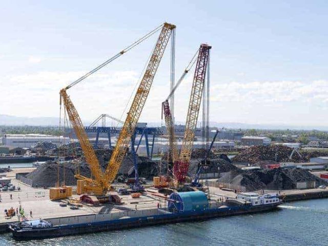 Liebherr LR13500 and LR11000 tandem lifting a TBM onto a barge in Kehl, Germany.