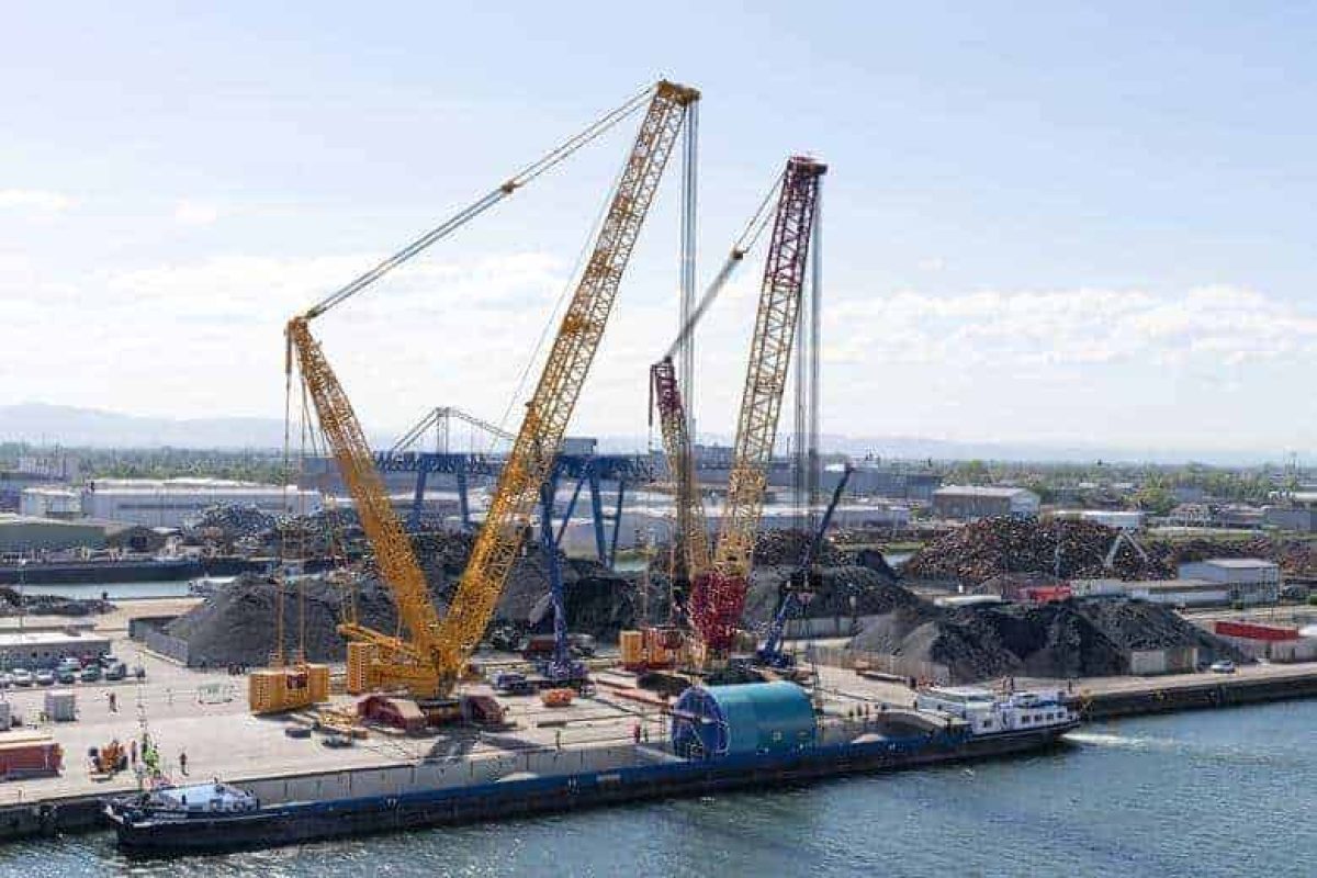 Liebherr LR13500 and LR11000 tandem lifting a TBM onto a barge in Kehl, Germany.